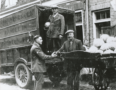 875350 Afbeelding van een vrachtauto en een handkar met witte kolen, voor het woonhuis en pakhuis van Frans Dussenbroek ...